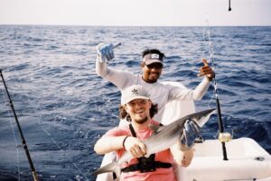 Darragh, Customer Success Associate, holding a successful catch on a fishing charter.