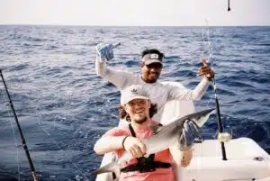 Darragh, Customer Success Associate, holding a successful catch on a fishing charter.
