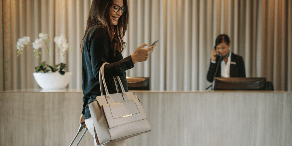 Woman texting on phone in hotel lobby