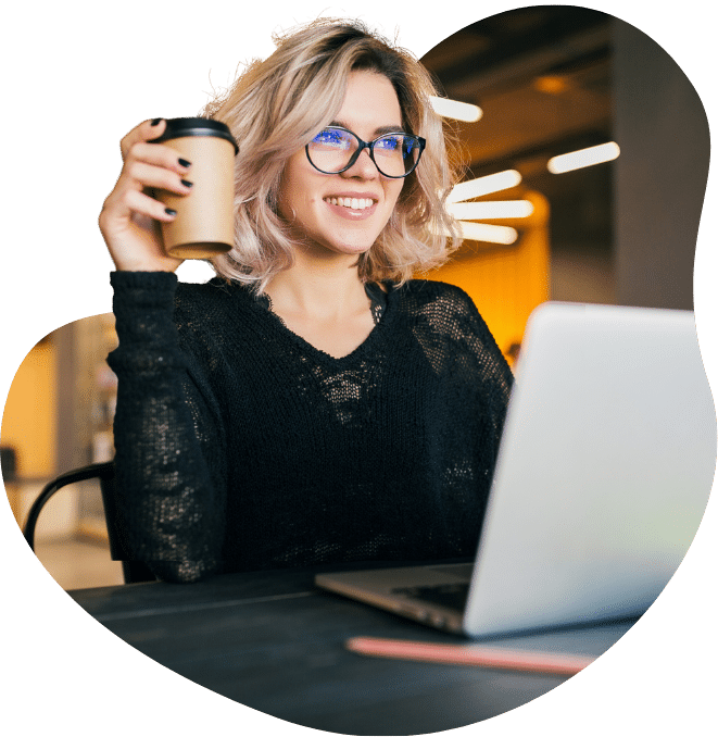 Woman at Laptop Holding Coffee