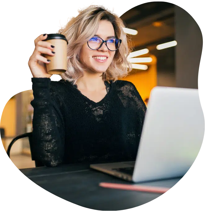 Woman at Laptop Holding Coffee